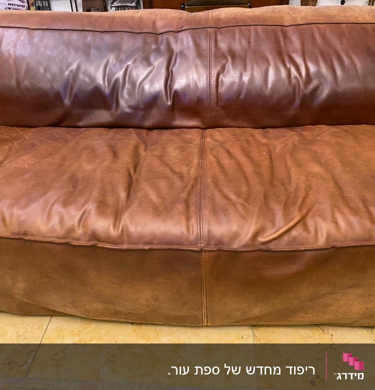 ספה חומה מרופדת בעור עם קמטים קלים